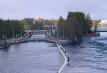 Den nuvarande Joensuu kanalen. Den ena v�ggen av den gamla slussen finns bakom den bl�a skylten Joensuu och minnesm�rken ligger p� h�ger av skylten vid forsen.