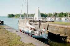 Segelb�t slussar ut i V�nern ur Sj�torps sista sluss med den fina tr�fyren i bakgrunden.